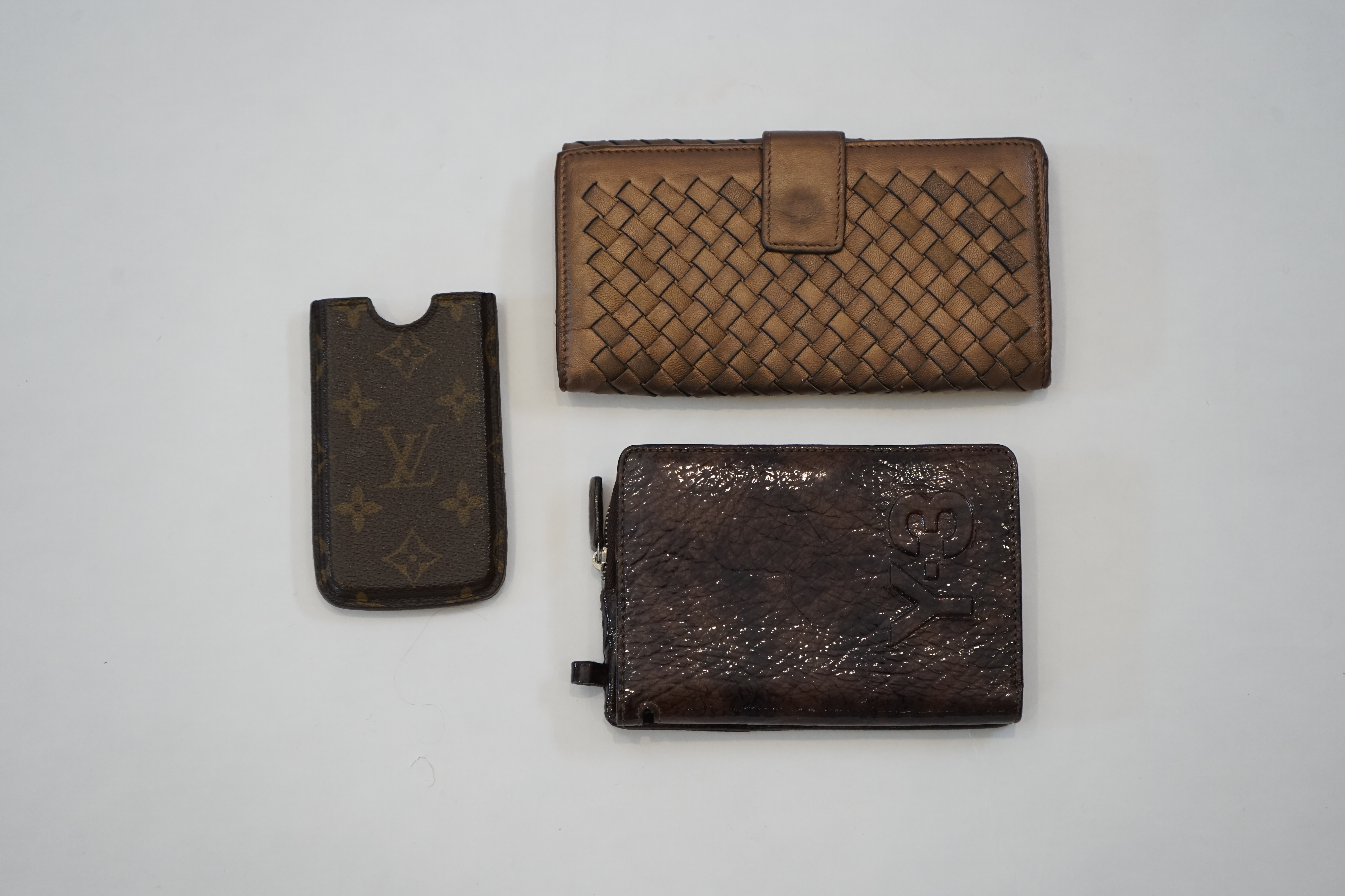 A Bottega Veneta purse, a Y-3 purse/wallet and a Louis Vuitton phone case